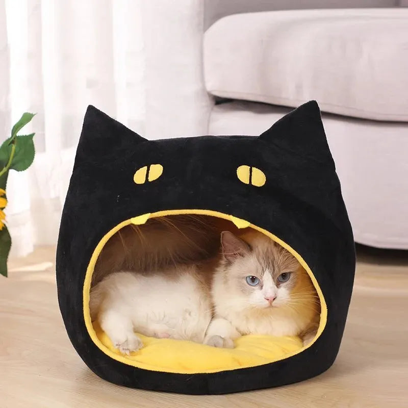 Grey cat-shaped enclosed pet bed with a round opening, sitting on a wooden floor.