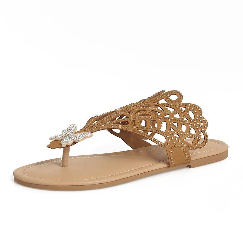 Women's black slip-on sandals with rhinestone details, a flip-toe strap, and a flat rubber sole.