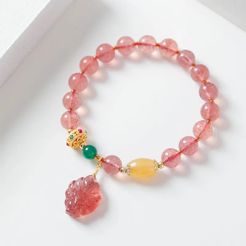 Women's polished crystal beaded bracelet with strawberry quartz and a nine-tail fox charm.