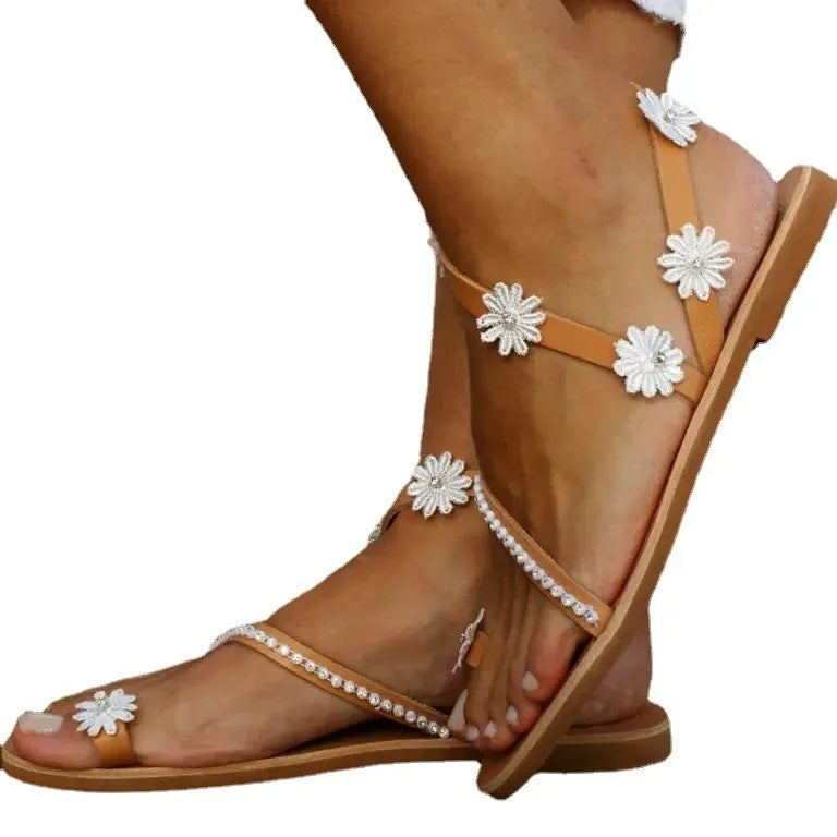 Brown ladies flat sandals with floral pattern, herringbone toe, and rubber sole.