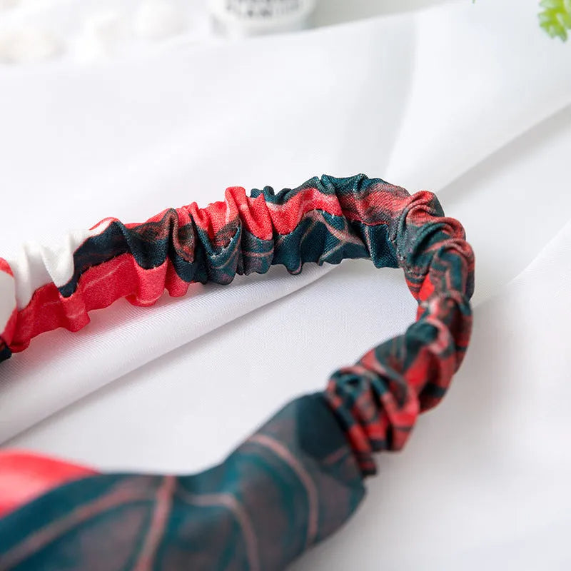 Red cloth headband with woven banana leaf design and cross hair pattern