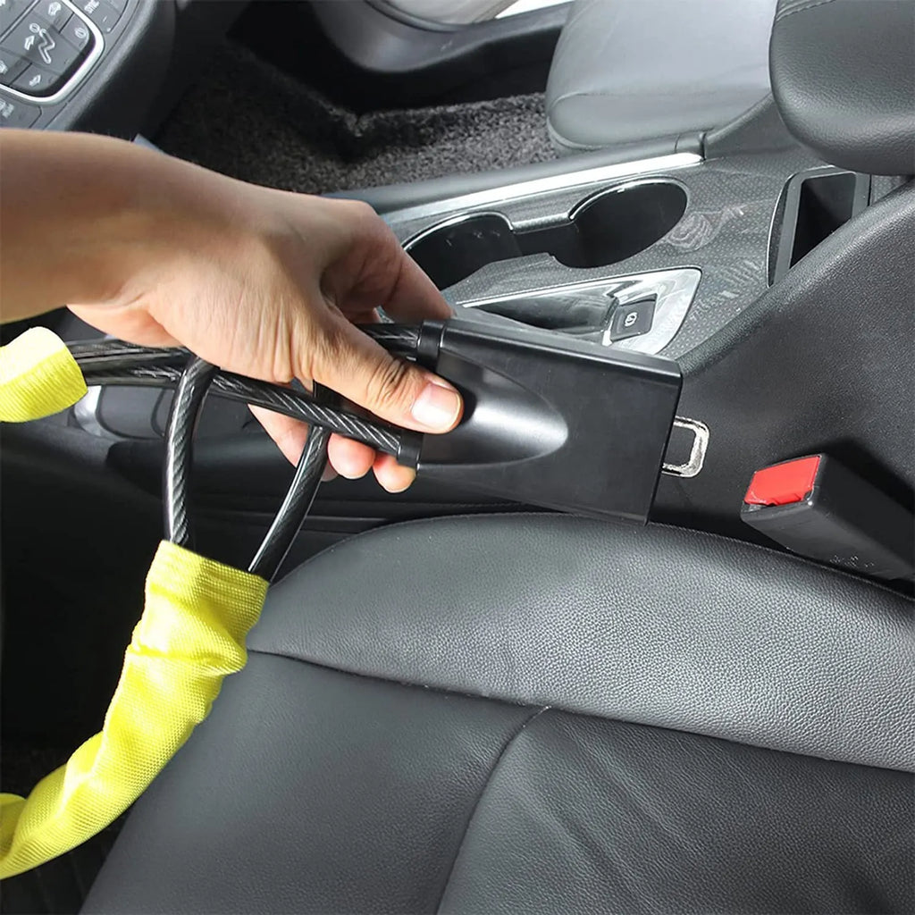 Red iron car steering wheel lock with brass core for General Motors vehicles on a steering wheel.