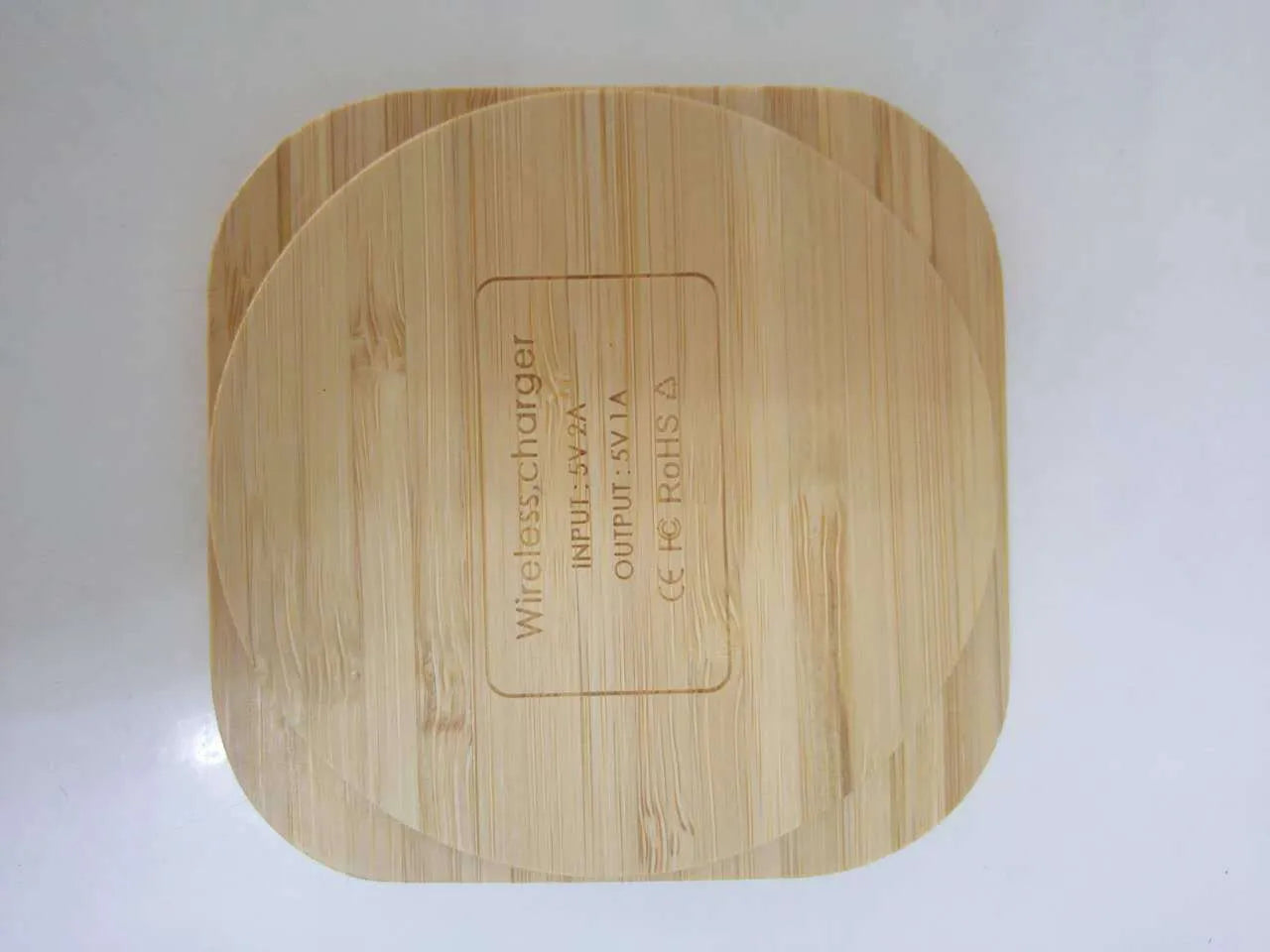 Square brown wooden bamboo 5W Qi wireless charging pad on a table