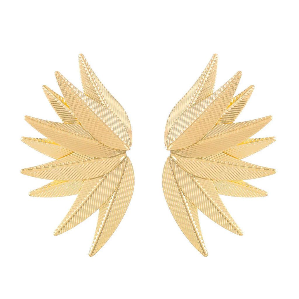 Gold and white alloy leaf shape patch earrings on a flat surface