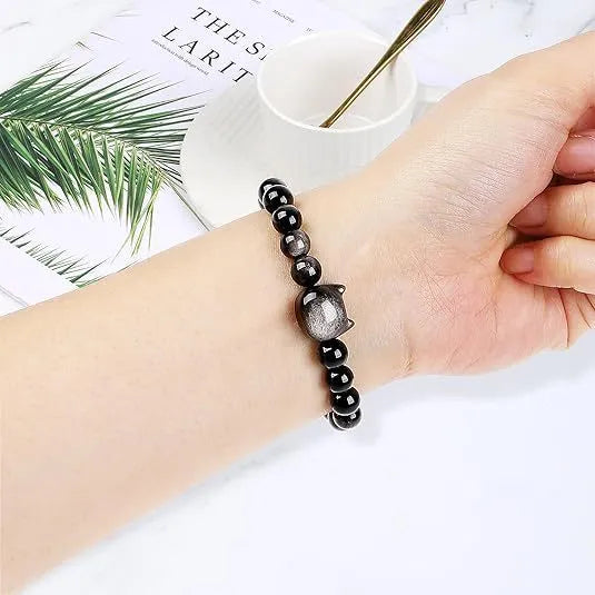 Handmade natural stone bead bracelet with silver cat pendant on neutral background