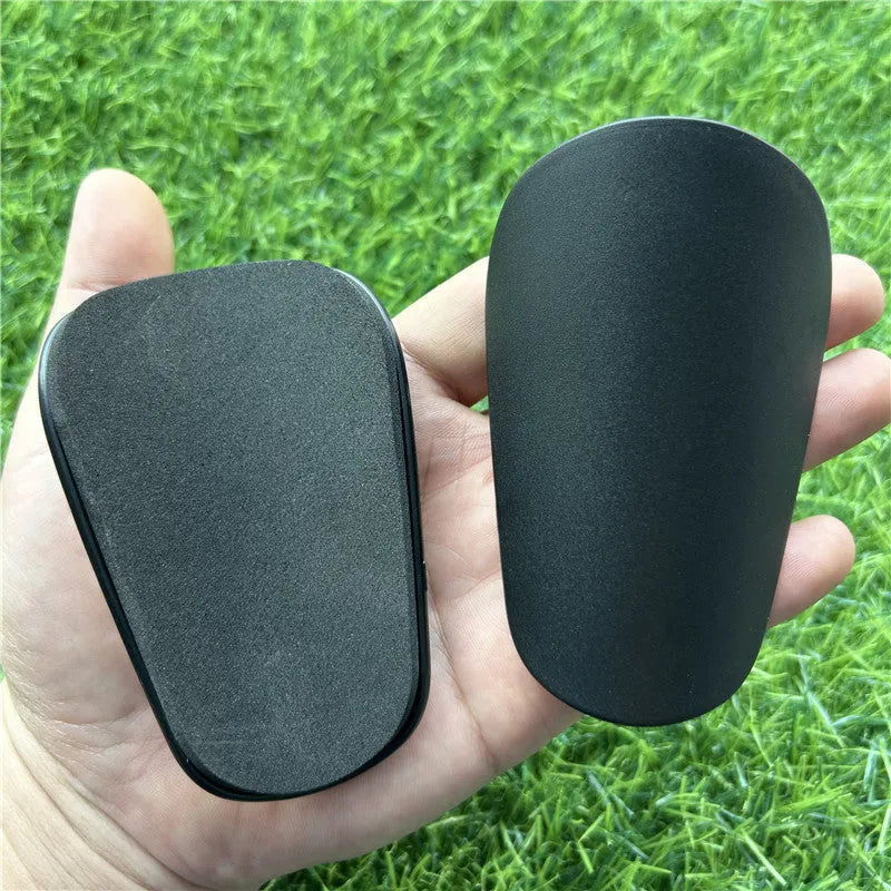 Extra small mini football shin guards in black and white, measuring 8x5cm