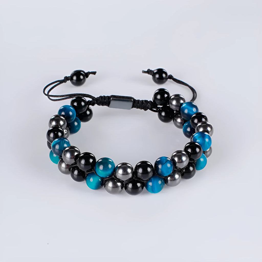 Close-up of a unisex alloy bracelet featuring green cat's eye tiger eye stones and red iron stone with an auspicious elephant charm.