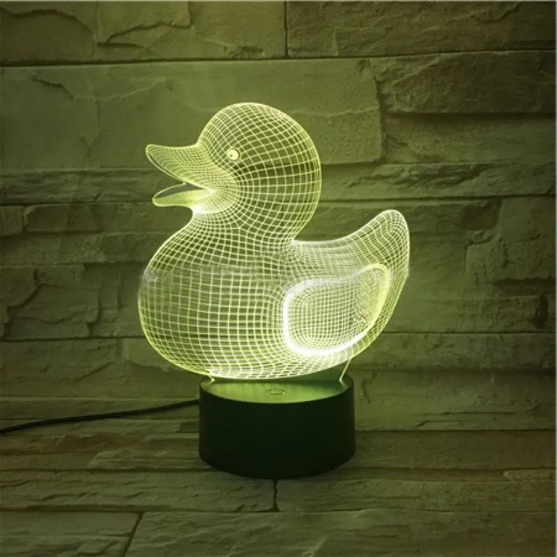 Little yellow duck 3D night light on a table with remote control, displaying a blue colour.