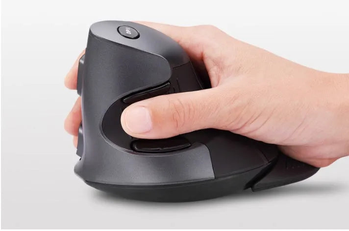 Black M618 wireless vertical ergonomic mouse on a desk next to a laptop, showing its contoured shape and scroll wheel.