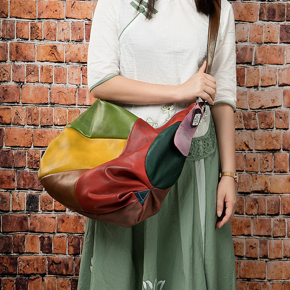 Brown cowhide leather crossbody travel bag open to show a 15-inch laptop and iPad inside.