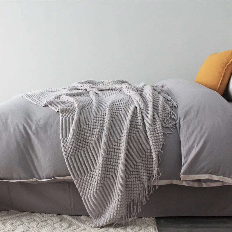 Small light grey polyester nap blanket folded, showing its texture and size.