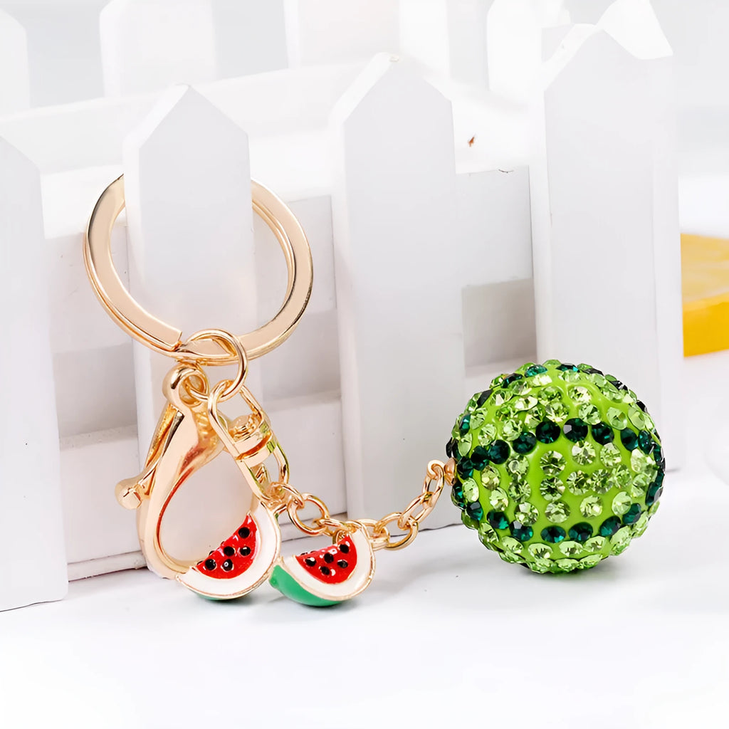Green watermelon-shaped metal keychain on a white background