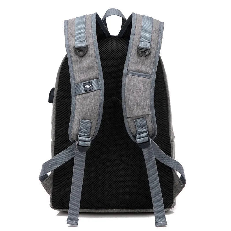 Canvas backpack with USB charging port shown in grey colour, featuring multiple pockets and straps.