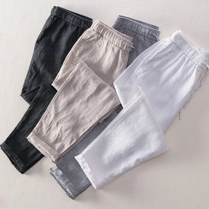 Men's straight leg linen trousers in light grey on a hanger.