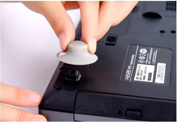 Four grey durable plastic laptop cooling pads, two large and two small, on a wooden desk