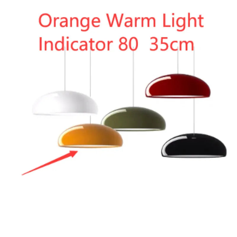 Orange iron Danish-style pendant lamp with adjustable cable above a restaurant table.