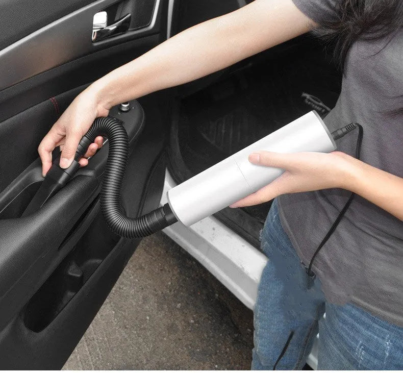 White car mini vacuum cleaner with brush nozzle and long flat nozzle on car seat