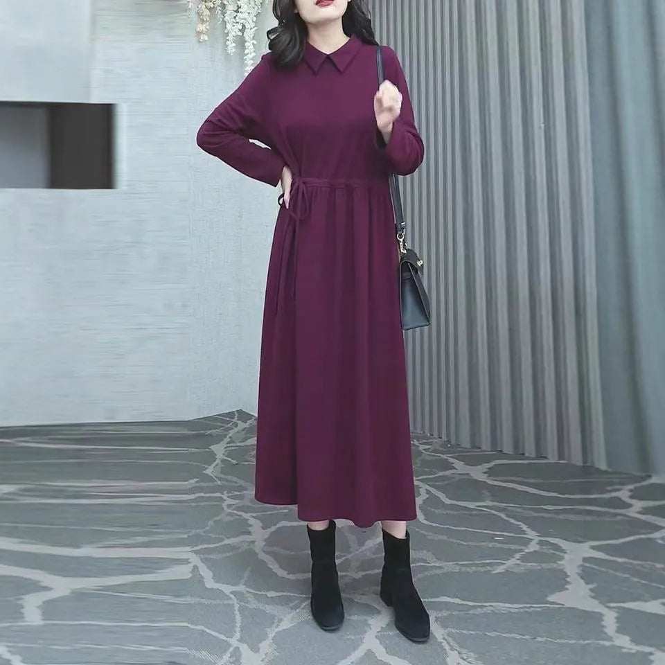 A woman wearing a solid purplish-red long-sleeve maxi dress with extra-long sleeves, suitable for autumn and winter.