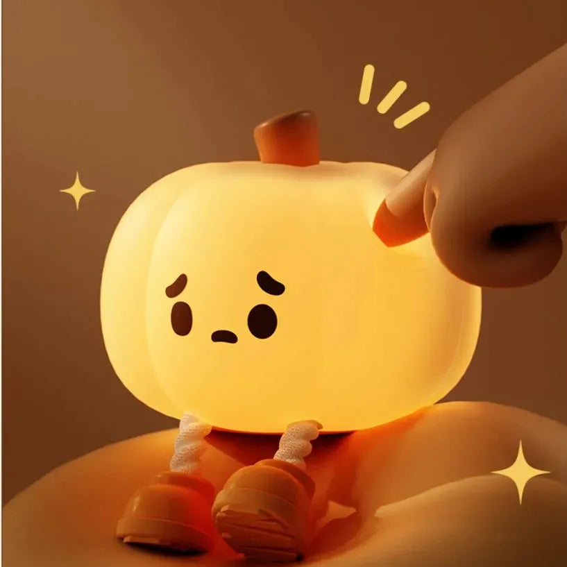 Soft orange silicone pumpkin-shaped night light with a gentle glow, sitting on a surface.