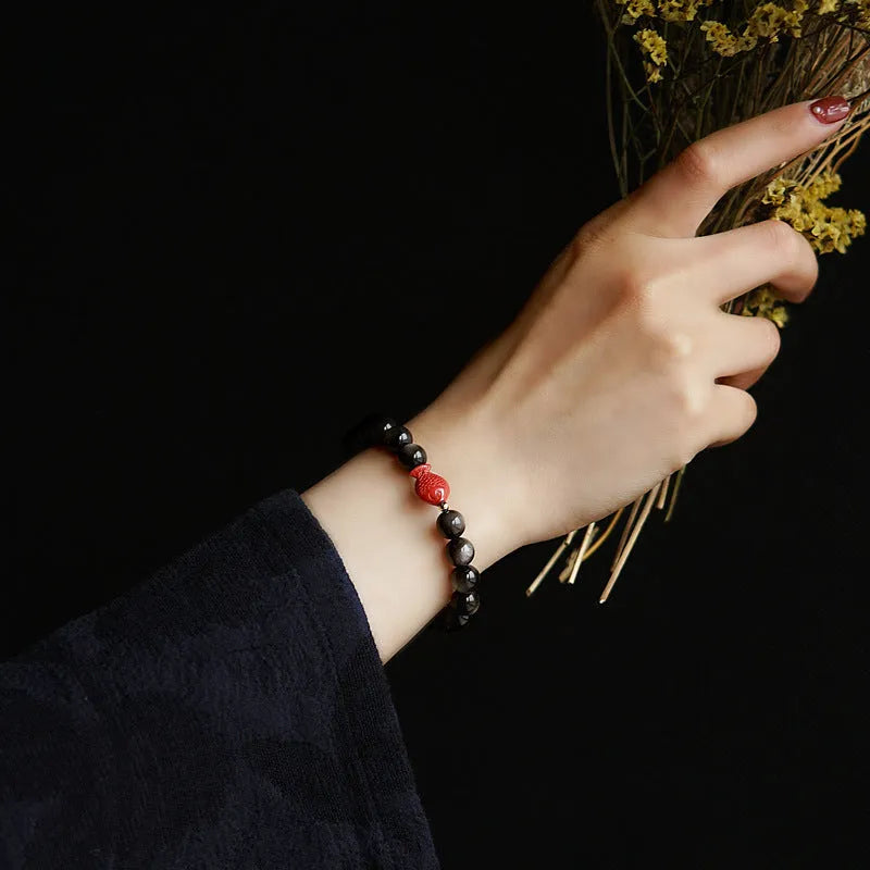 Natural obsidian bracelet with cinnabar fungal growth in round beads, showing stone patterns
