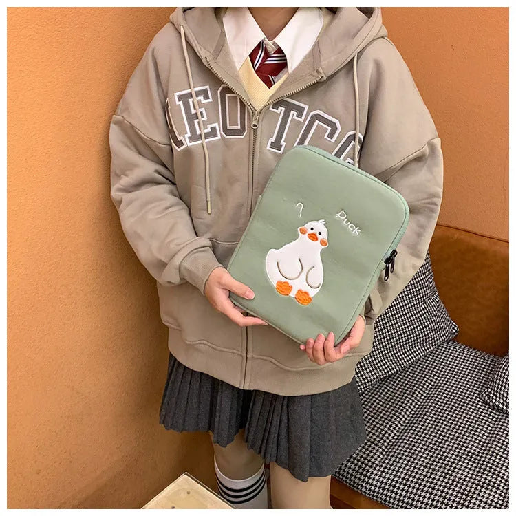 Blue cotton tablet case with embroidered cartoon duck design, showing zipper closure and protective frame.