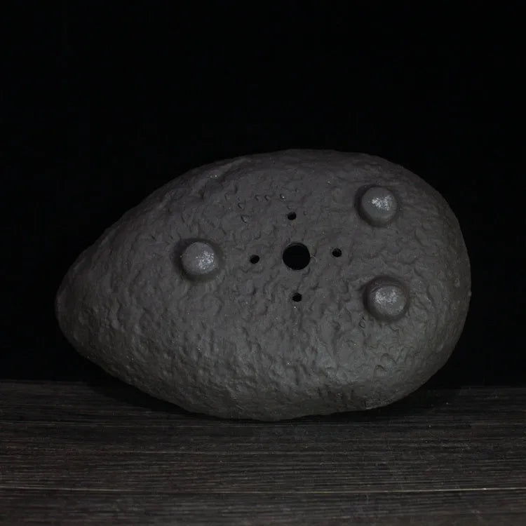 Handmade purple clay flower pot showing unique shape and natural ceramic texture