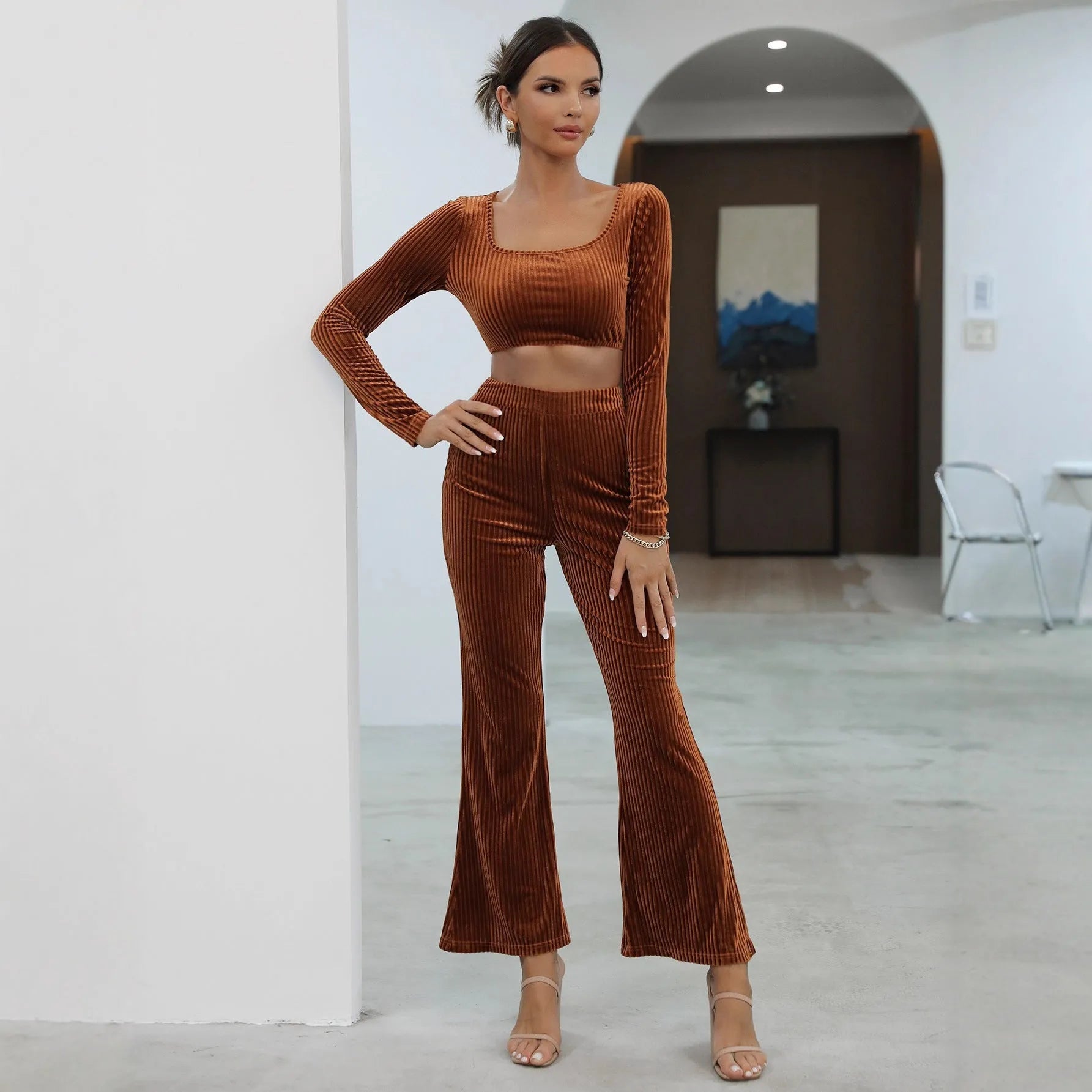 Caramel coloured women's long sleeve sweater and matching straight-leg trousers set on a hanger.