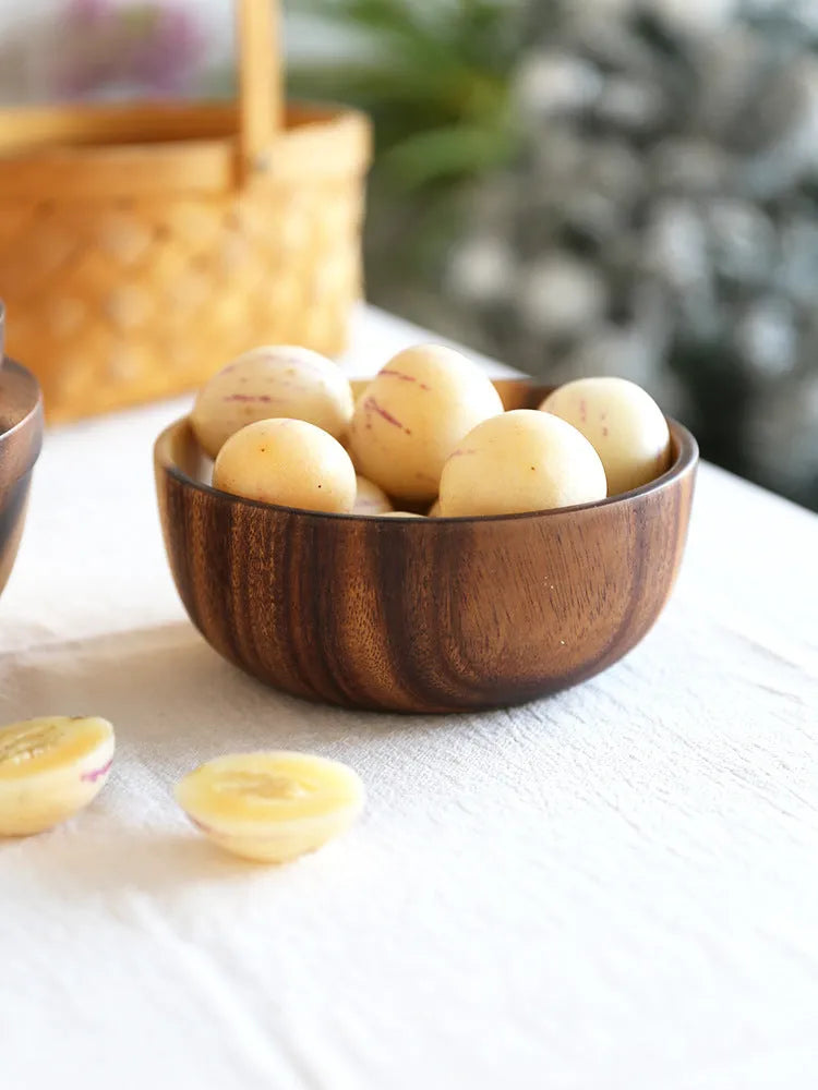 Handmade brown wooden bowl set showing multiple sizes from small to large on wooden table
