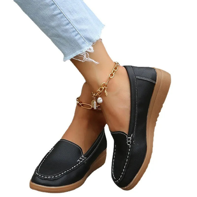 Women's black PU leather flat shoes with round toe and rubber sole on a white background.