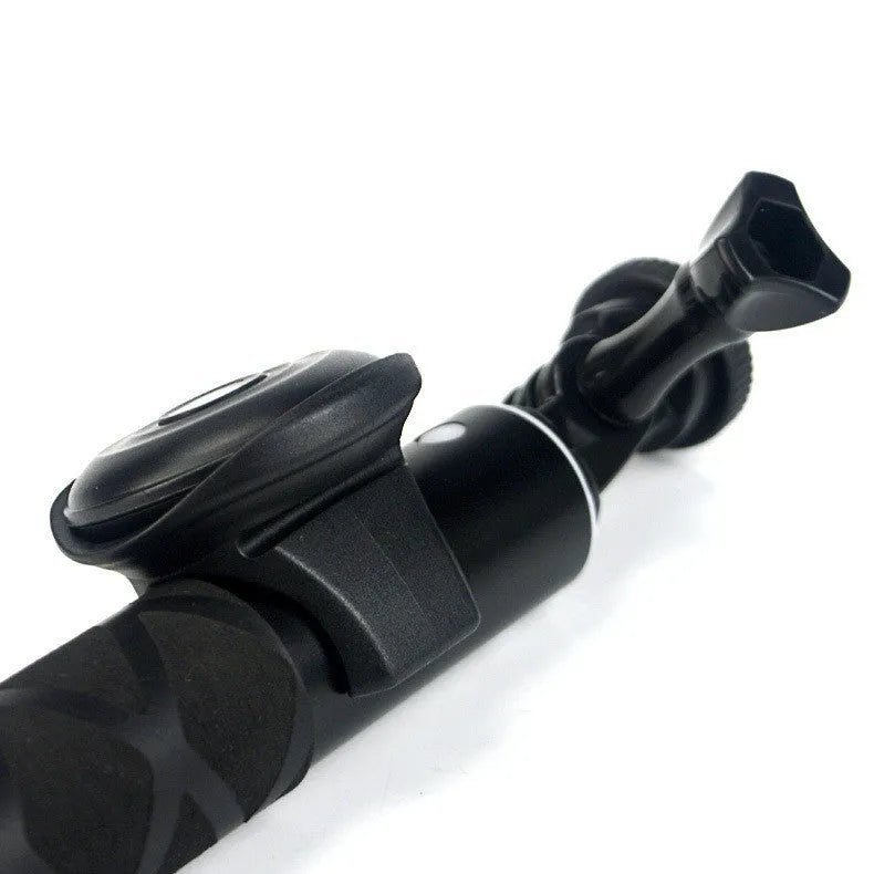 Small black Snap Bluetooth remote control for smartphone and camera shutter release, shown on a hand for scale.