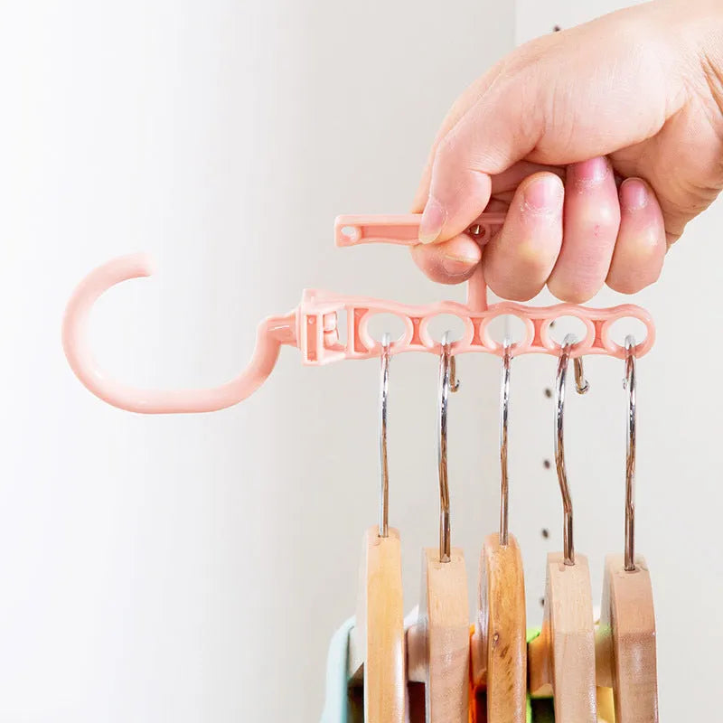 Blue revolving plastic wardrobe hanger with five branches and a central handle.
