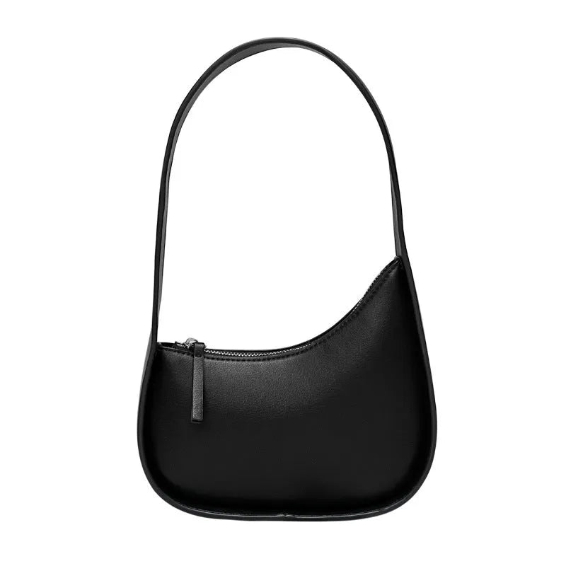 Small half moon shaped leather women's shoulder bag with a wide strap, shown in light brown.