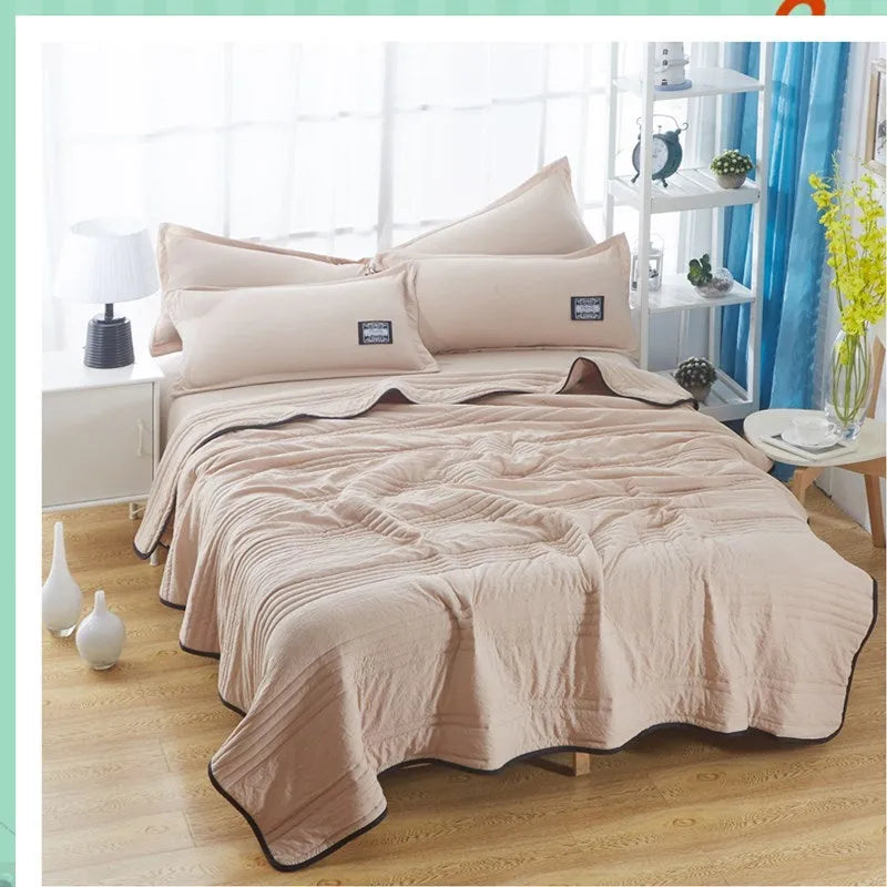 Lightweight seersucker summer quilt in various colours on a bed