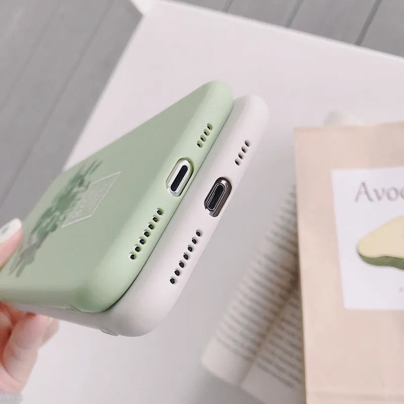 White silicone iPhone case with a detailed painted plant pattern on the back, showing its 360-degree protective edges.