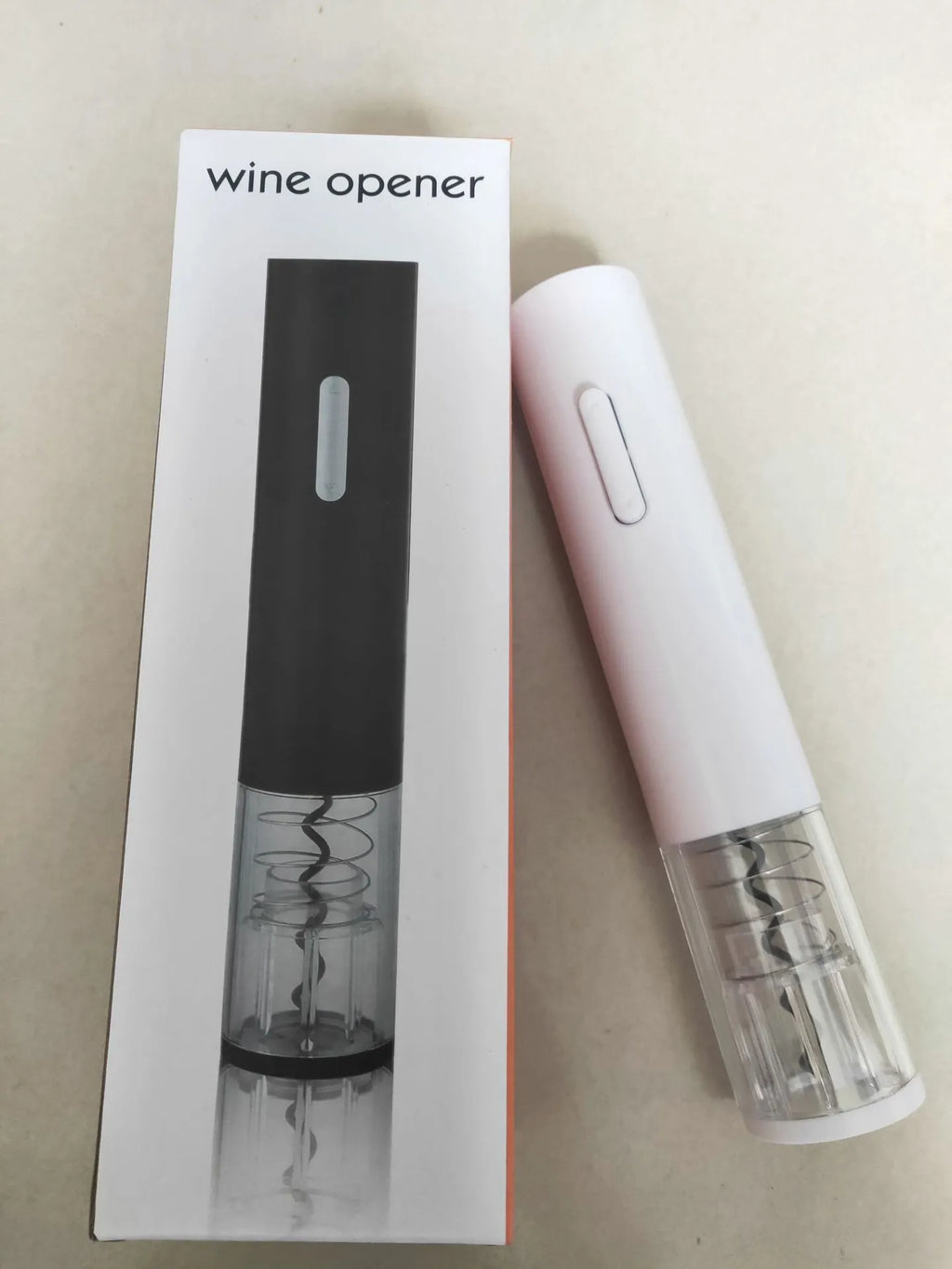 Black electric wine bottle opener with automatic corkscrew and integrated foil cutter on wooden table