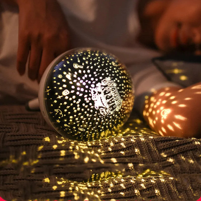 Black and white rotating cartoon-style starlight projection lamp on a surface.