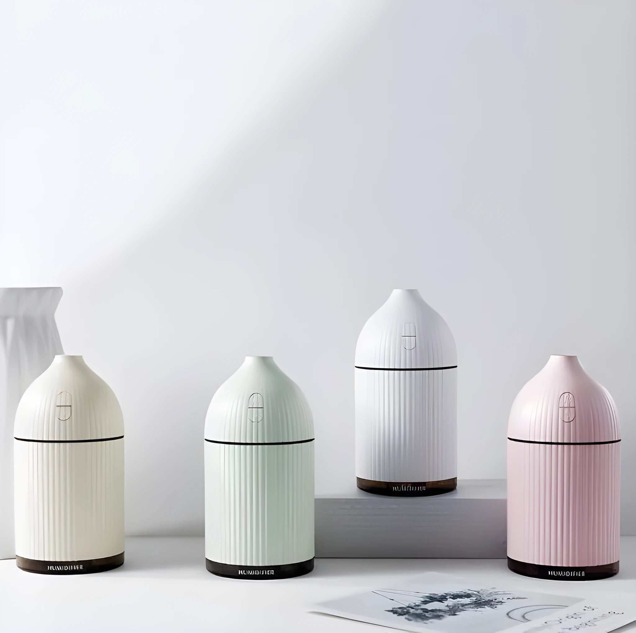 White USB-powered ultrasonic aromatherapy diffuser and humidifier with LED light on a wooden surface.
