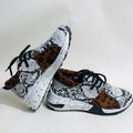 Women's black suede casual sneakers with a low wedge heel and round toe on a white background.
