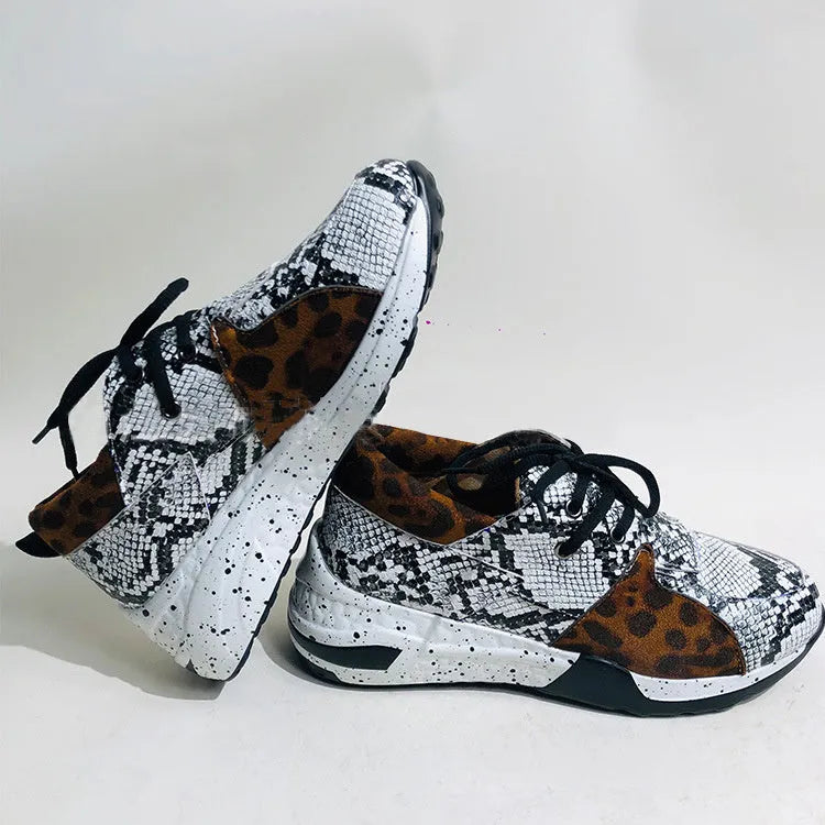 Women's black suede casual sneakers with a low wedge heel and round toe on a white background.
