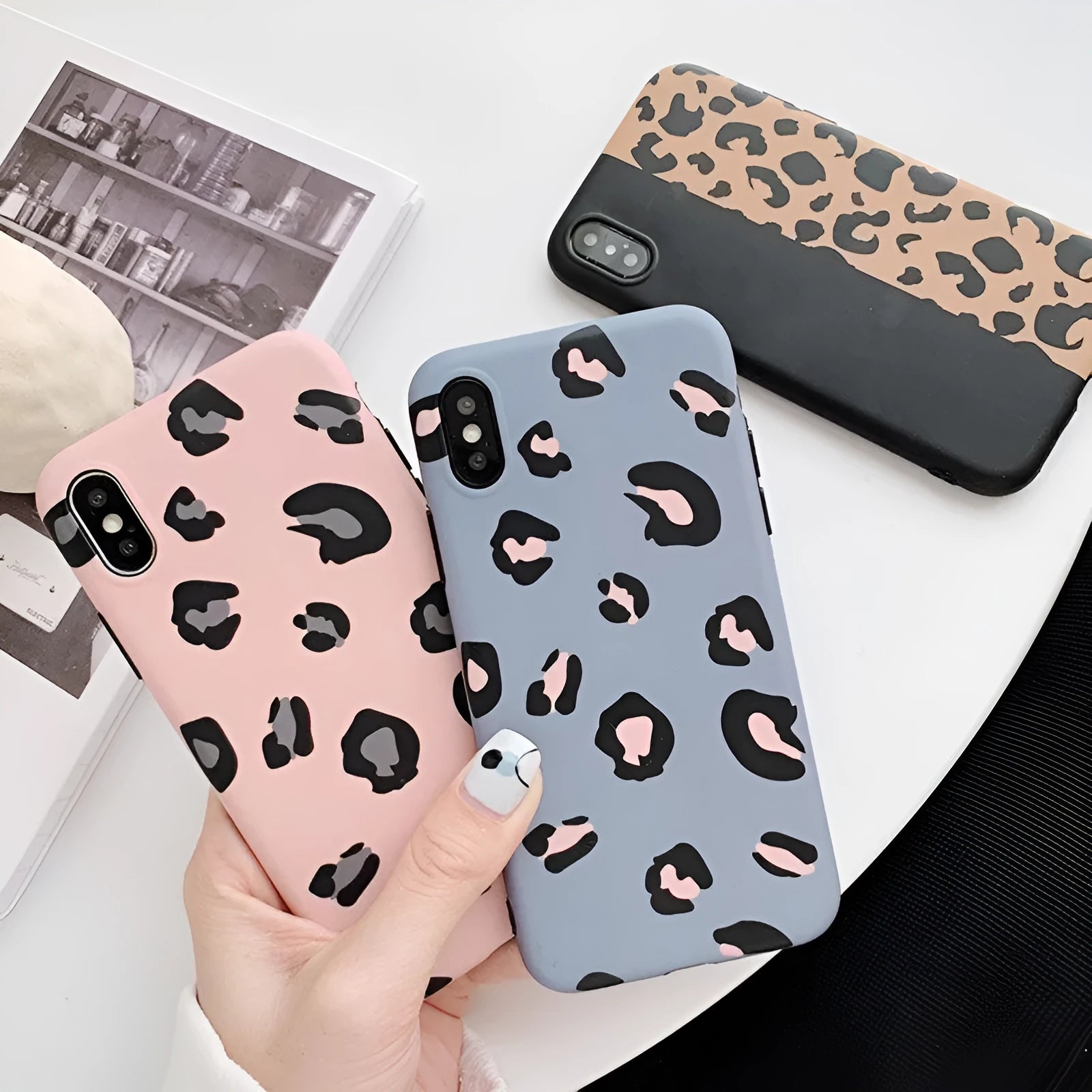 Leopard print protective mobile phone case for iPhone in black, blue, and pink colour options.