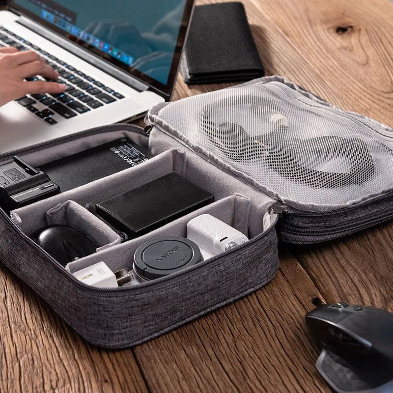 Grey waterproof electronics organiser bag with double-layer interior, handle, and zipper closure