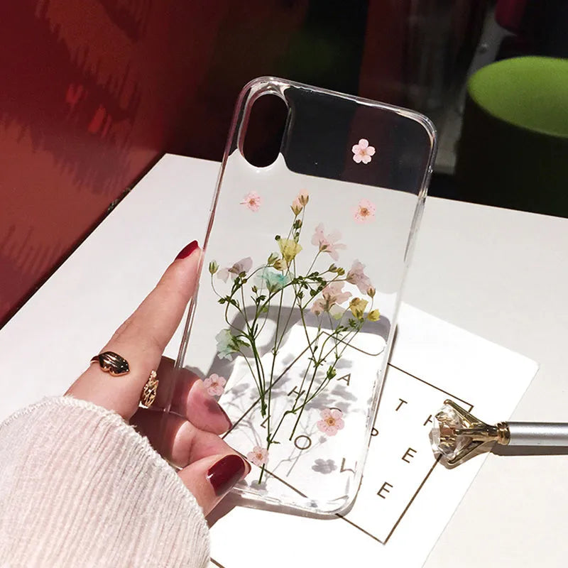 Clear iPhone case with real pink dried flowers preserved under glossy epoxy resin.