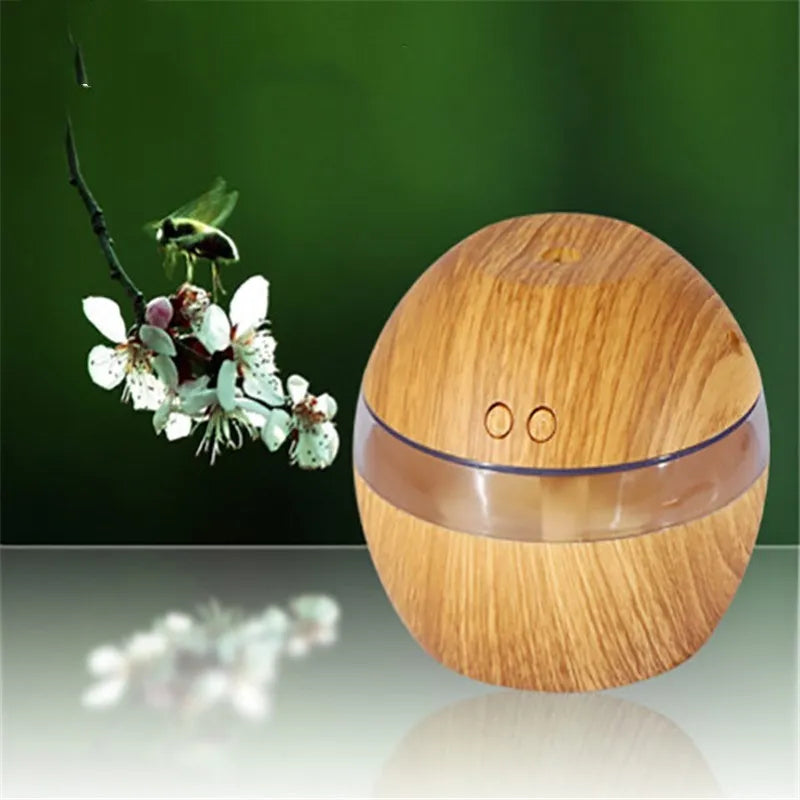 Brown wood grain portable USB humidifier on a desk next to a laptop.