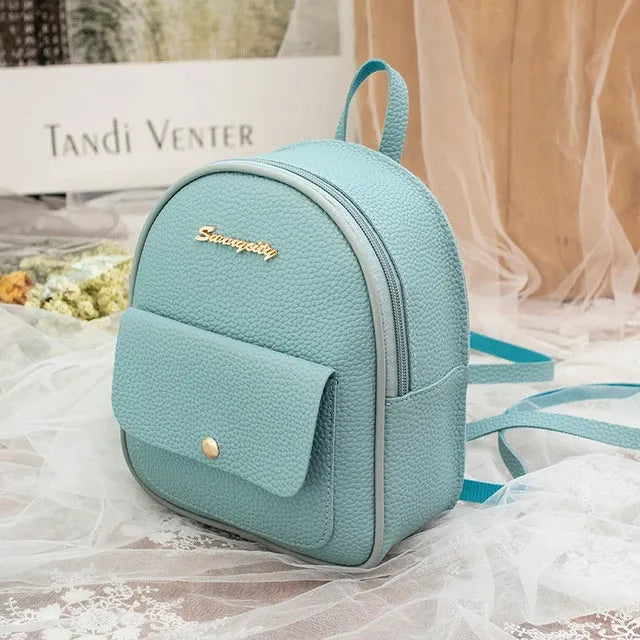 Compact black PU leather women's shoulder backpack worn crossbody, showing zipper closure and simple design.