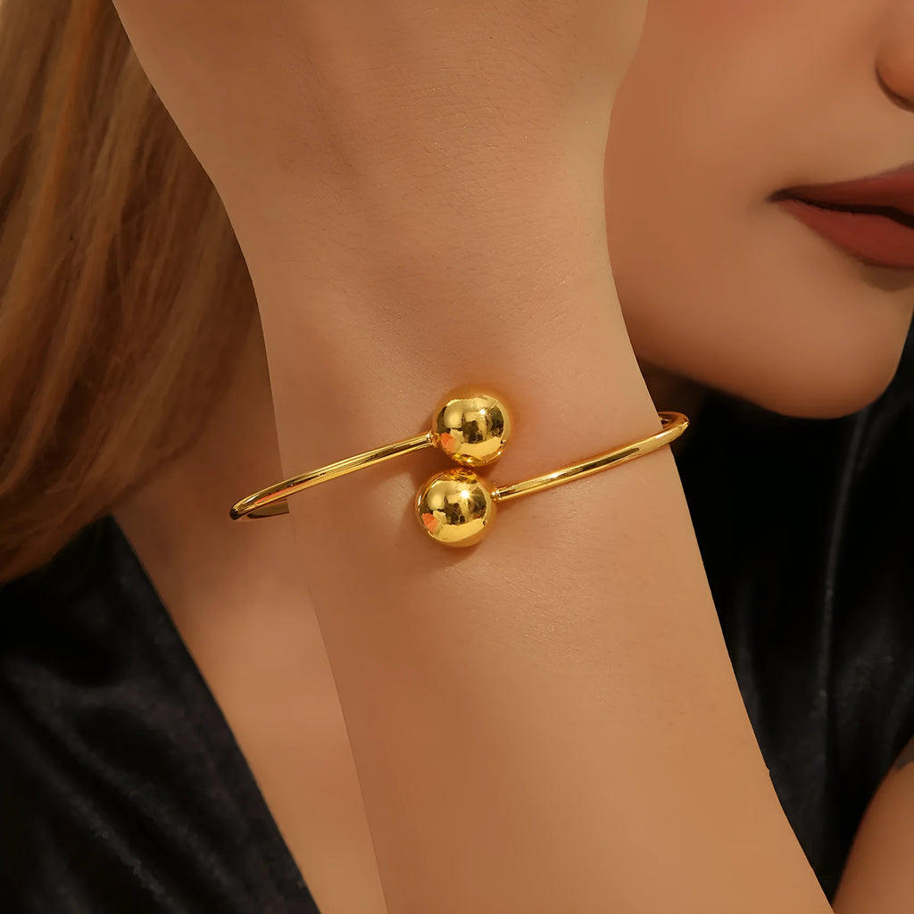 Golden copper plated 18k gold double bead opening bracelet on white background