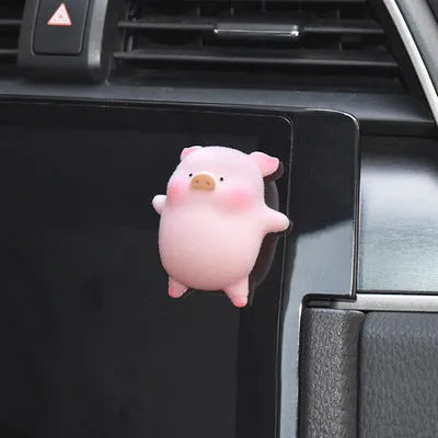 A cute cartoon pig resin figurine car decoration accessory on a dashboard.