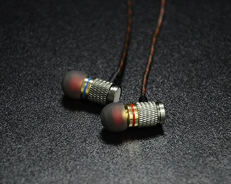 Close-up of wired in-ear headphones with metal housing, silicone cable, and TPE earplugs shown in standard and with microphone styles.