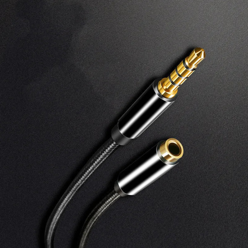 Black nylon braided 3.5mm aux extension cable coiled on a surface, 1.5 metre length
