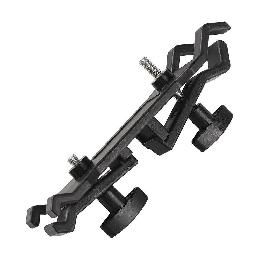 Black plastic umbrella clip attached to a tripod leg, holding a folded umbrella.