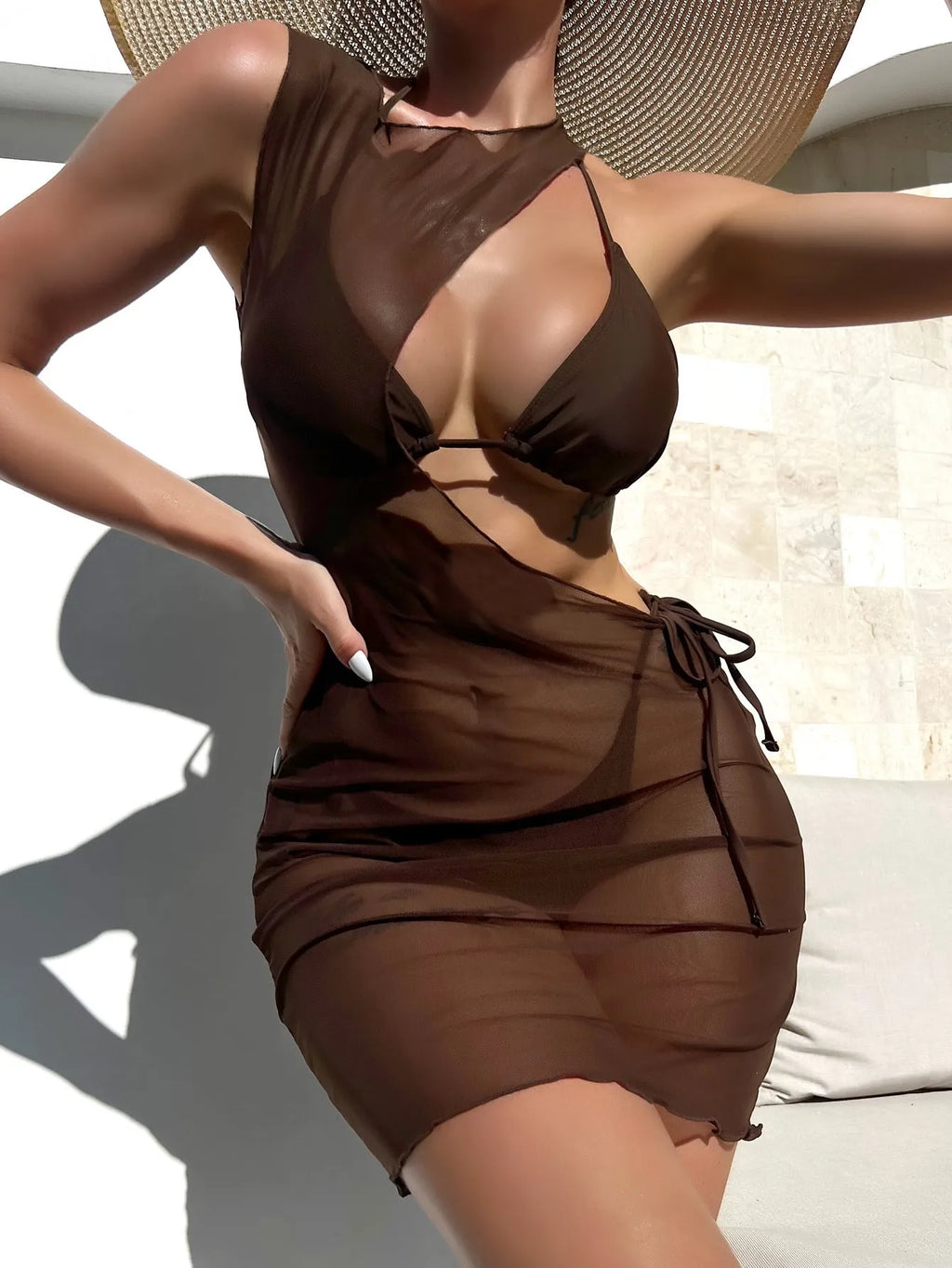 Brown women's three-piece swimsuit set comprising a bra, shorts, and blouse on a plain background.